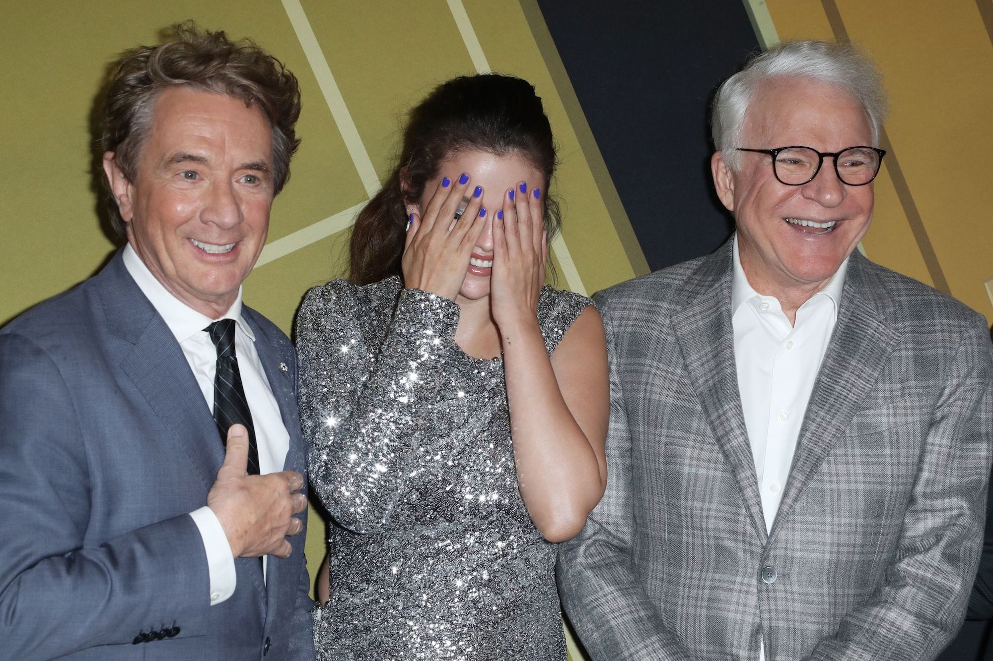 Selena Gomez having a fun moment with her co-stars Steve Martin and Martin Short on the red carpet.