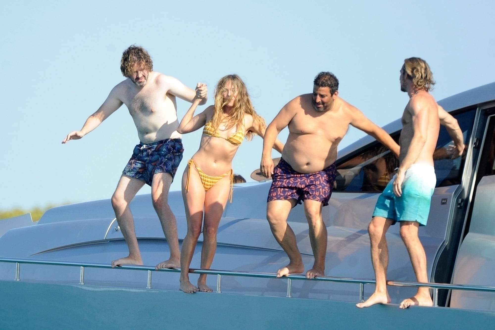 Margot and her husband jumping off the side of the boat along with some of their friends.