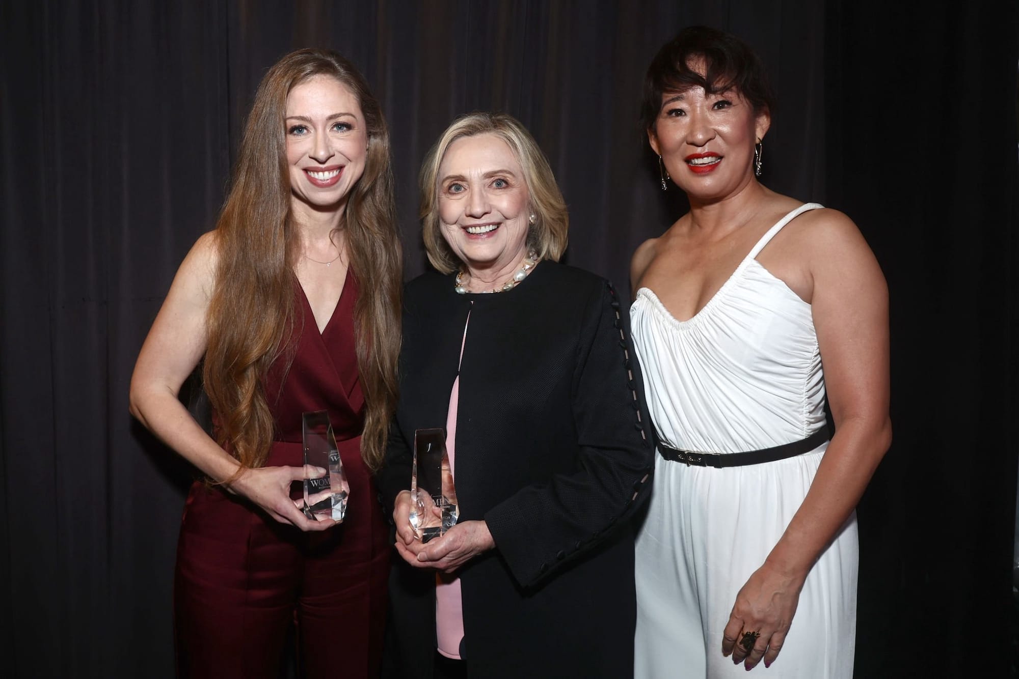 Chelsea Clinton and Hillary Clinton posing with thier awards alongside 'Killing Eve' actress Sandra Oh.
